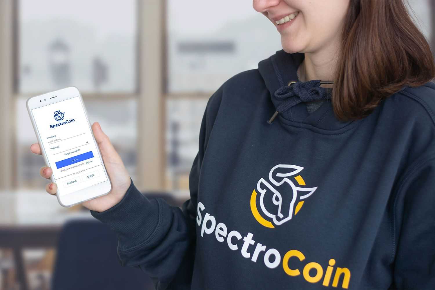 Девушка с телефоном с приложением SpectroCoin для Android.